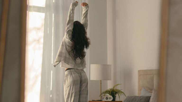 Person doing a calm morning routine stretching near a bright window