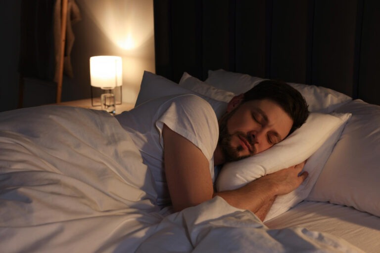 Person sleeping, warm light, a calm and still bedroom atmosphere at night.