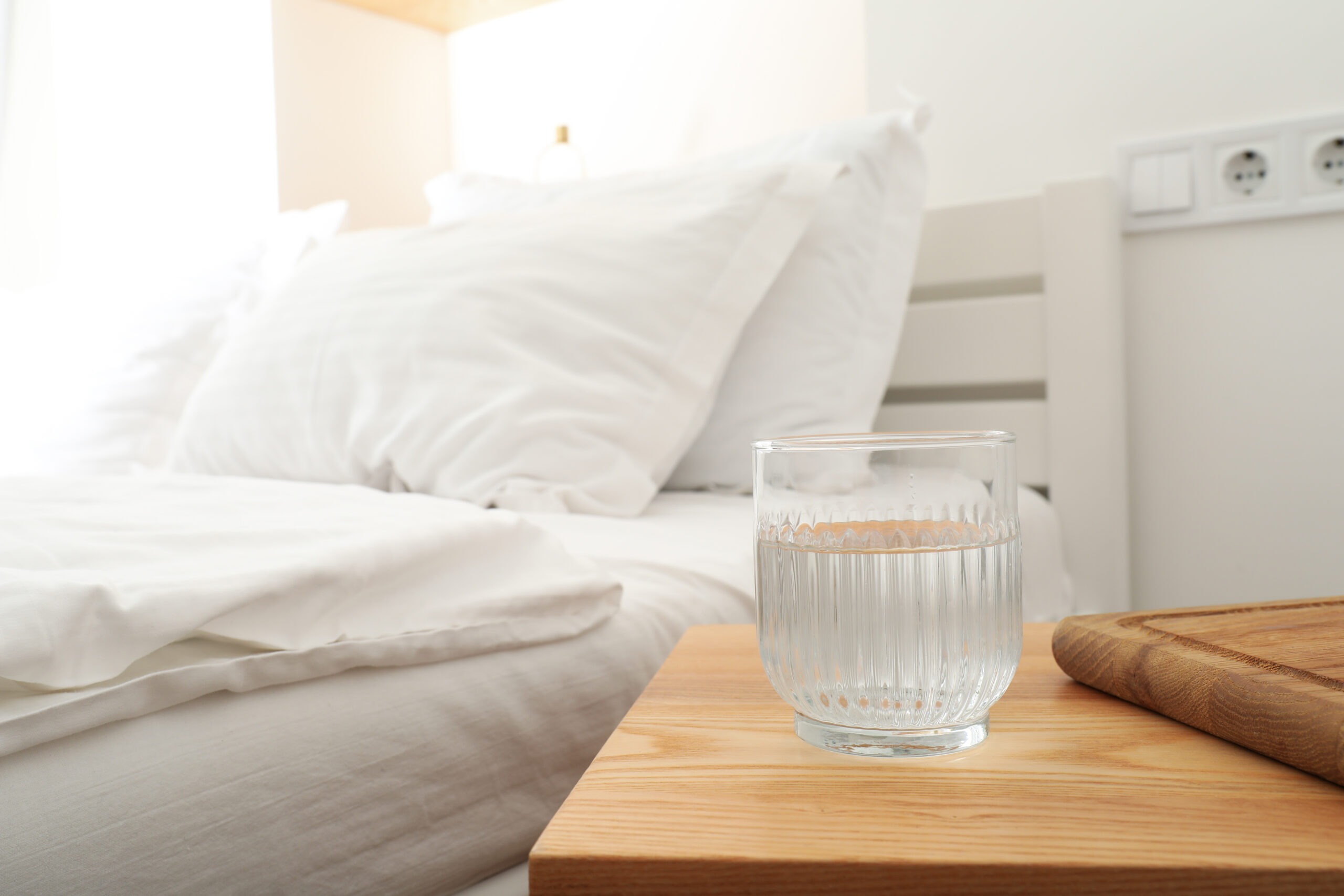 Calm bedroom with a glass of water on a bedside table