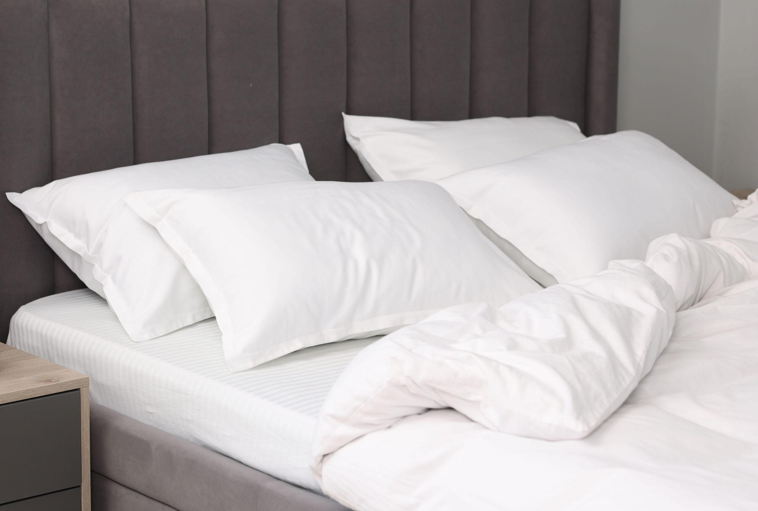 Neatly arranged regular pillows on a bed set up as pregnancy sleep support